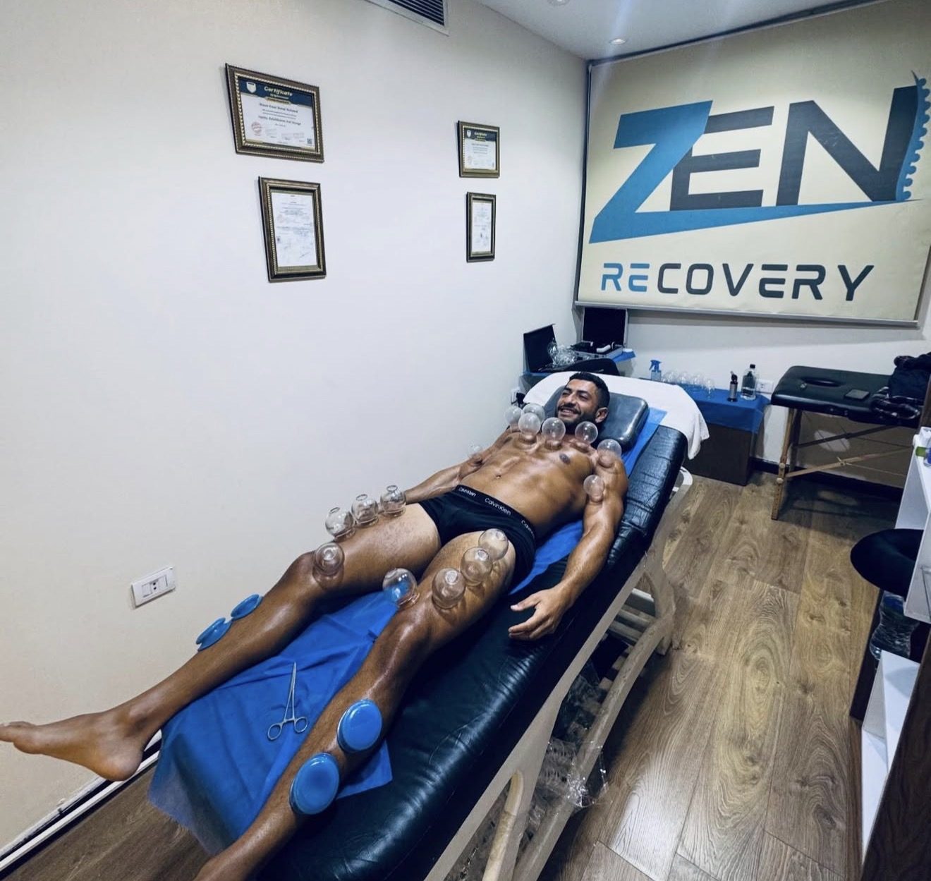 The Zen Recovery room in Cairo: a client under glass and silicone cups, certificates and the logo on the wall